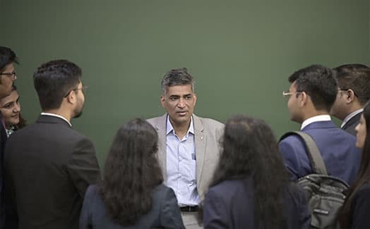 A faculty member in discussion with students in an XLRI classroom
